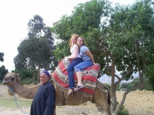 Students riding a camel on an educational tour to Morocco